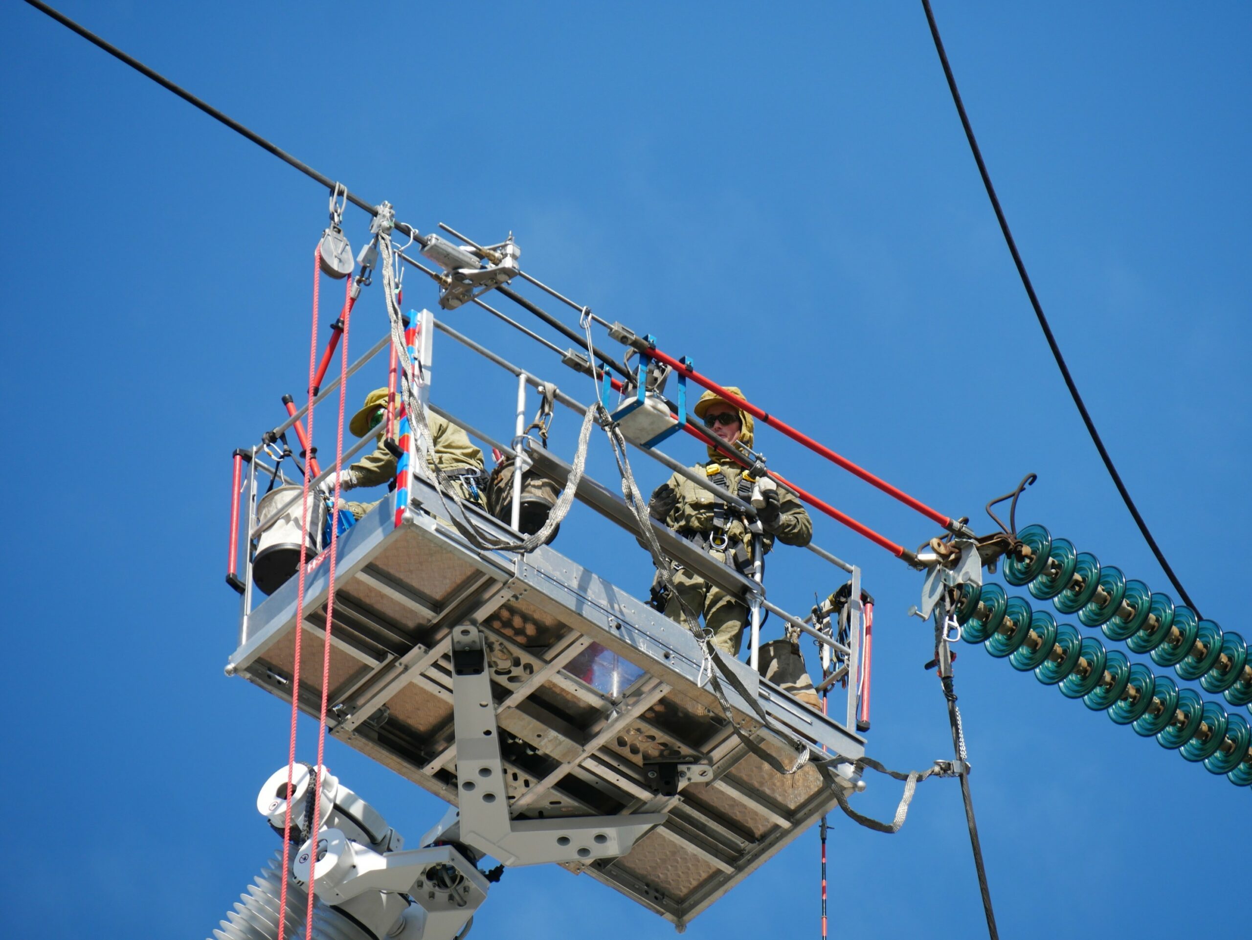 Un opérateur sur la PEMP 414 TBI réalise une réparation sur une ligne aérienne haute tension