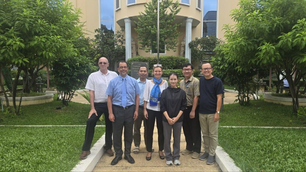 Un groupe de personnes prend la pose à l'extérieur du siège d'Electricité du Cambodge