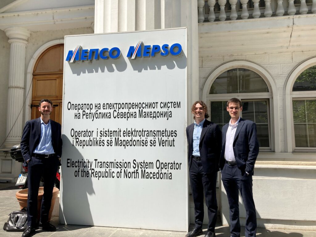 three men standing alonside MEPSO poster in North Macedonia