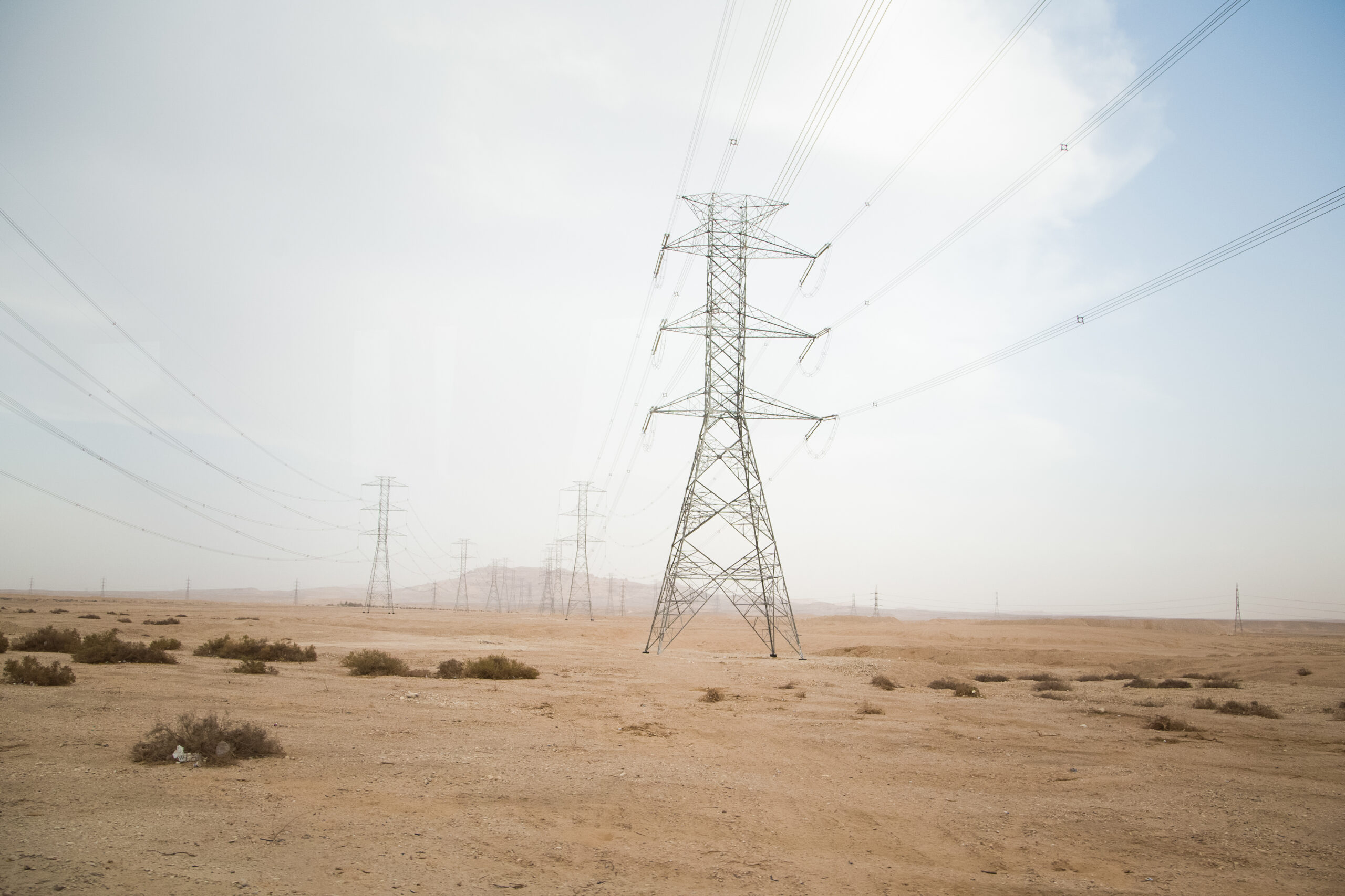 lignes électriques dans un paysage désertique avec quelques buissons