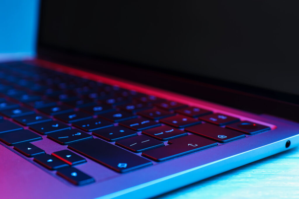gros plan sur le clavier d'un ordinateur dans des couleurs néons bleu et rouge